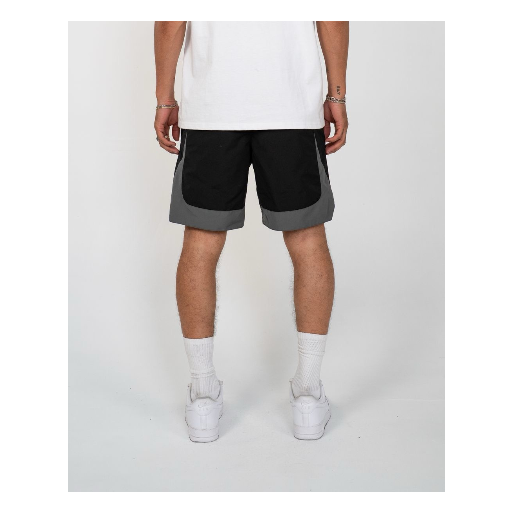 Person wearing black and gray shorts on a white background