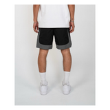 Person wearing black and gray shorts on a white background